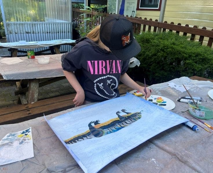 student painting a goanna